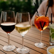 Verres de vin rouge, vin blanc et cocktails légers posés sur une table conviviale en terrasse